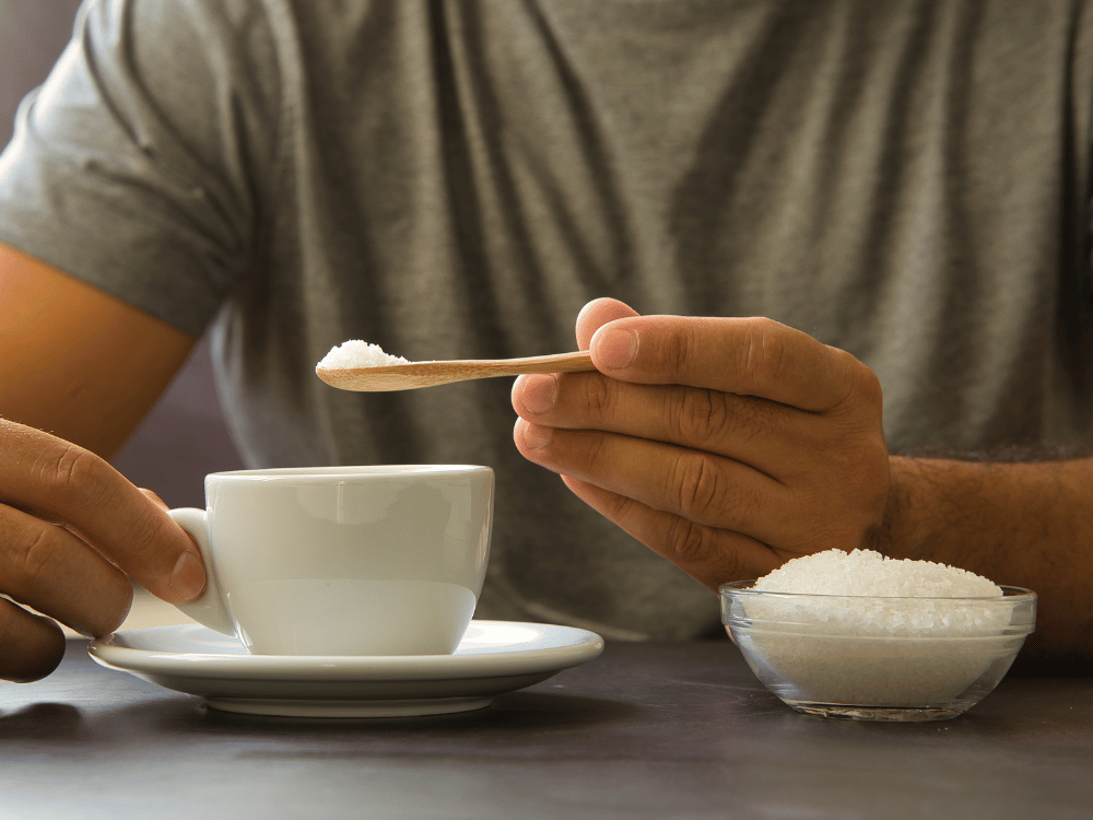 Muškarac sipa beli šećer u kafu